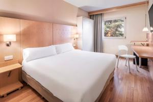 阿尔甘达·德尔·雷伊B&B HOTEL Madrid Arganda的酒店客房设有一张白色大床和一张书桌