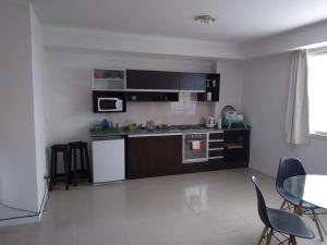布宜诺斯艾利斯STRADA II的厨房配有黑白电器和桌椅