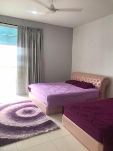 瓜埠FR Comfort SEAView Kuah, Langkawi的卧室内的两张床,配有紫色床单和地毯