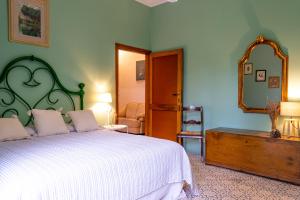 蒙特普齐亚诺波利赞那圣贝别墅的一间卧室配有一张大床和镜子