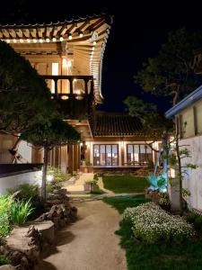 庆州HanokInn的夜间的房子,有一条通往房子的路径