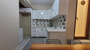 凡城Padishah Suite Otel的厨房配有白色橱柜和桌椅