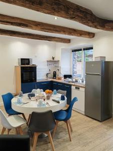 Saint-Malon-sur-MelA La Mémoire de Merlin & SPA的厨房配有桌椅和冰箱。