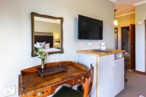 兰格班Le Mahi Guest House的配有一张带镜子的桌子和一张床的房间