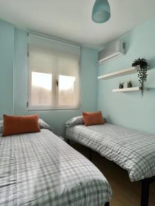 阿尔米利亚Apartamento y Parking的蓝色墙壁客房的两张床