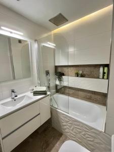 阿尔米利亚Apartamento y Parking的白色的浴室设有浴缸和水槽。