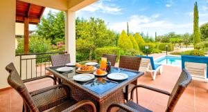 库克里亚2 bedroom Villa Oleander with private pool and garden, Aphrodite Hills Resort的一个带游泳池的庭院里的桌椅