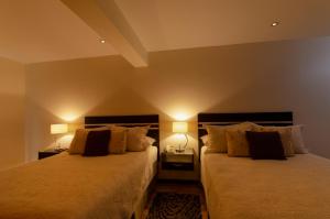 拉巴斯Hotel NC La Paz的卧室内的两张床,配有两盏灯