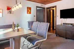 卡雷扎湖Sirena Carezza Apartment Karersee的客厅配有桌椅和电视。