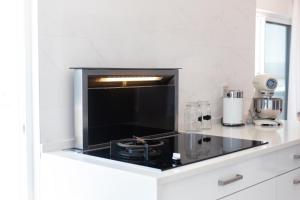 明德卢Penthouse with jacuzzi and sea view, Morabeza Deluxe的白色的厨房配有黑炉 顶部烤箱