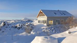 米湖Slow Travel Mývatn - Þúfa - Private Homestay的雪中的房子,有雪覆盖的地面