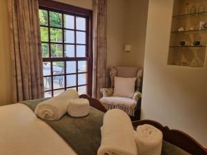 开普敦Schuilhoek Garden Terraces的客房设有床、窗户和椅子。