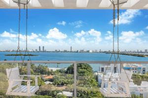 迈阿密Nomada Destination Residences - Quadro的阳台享有水景,配有白色椅子。