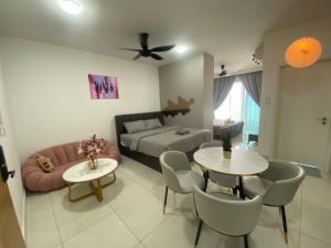 努沙再也Teega Suites, Puteri Harbour, Iskandar Puteri的客厅配有床、沙发和桌子