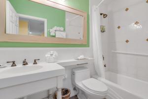 基拉戈Dove Creek Resort & Marina, Trademark Collection by Wyndham的一间带卫生间、水槽和镜子的浴室