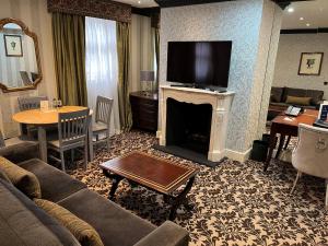 伦敦里奥纳德酒店的客厅配有沙发和壁炉及电视