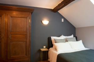 拉罗什-阿登Le Marronnier的一间卧室配有一张床和一扇木门