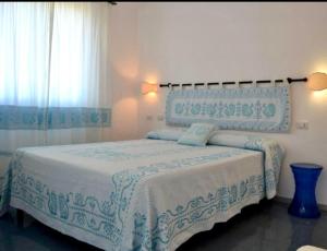 马戈马达斯皮斯齐纳别墅酒店的一间卧室配有一张带蓝白色毯子的床