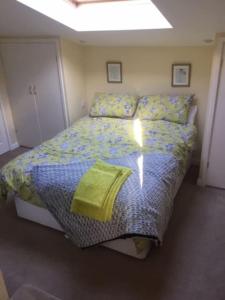 BredonBens Hollow with hot tub的一间卧室配有一张带黄色床单的大床