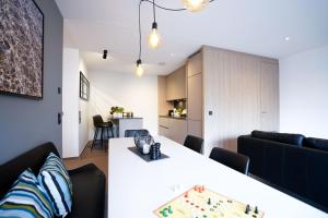 慕尼黑Max Lodging Serviced Apartments的客厅配有白色桌子和沙发