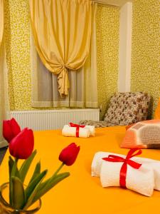 波罗维茨Hotel Forest Star on the Ski Slope的黄色客房,设有两张红色鲜花的床