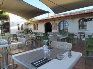 法沃内Les Villas de la Résidence U Veniqui的餐厅设有白色的桌子和绿色的椅子