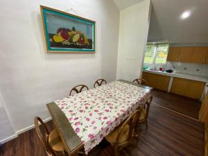 不拉士打宜Villa Berastagi Indah A32 - TEBU MANIS的用餐室配有桌椅和墙上的绘画作品