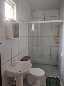 特林达德Trindade Hospeda - Estúdios e Casa Vila Trindade的白色的浴室设有卫生间和水槽。