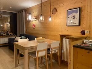 拉克吕萨Appartement cosy au pied des pistes的一间带木桌和椅子的用餐室