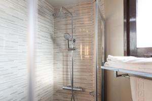 维克Hotel Can Pamplona的带淋浴的浴室和玻璃门