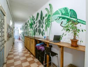 布加勒斯特T5 Social的客房设有一张桌子、一台笔记本电脑和墙上的植物