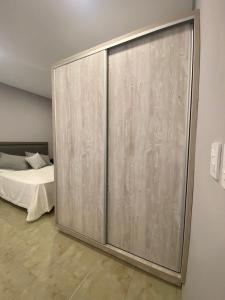 埃利萨镇PEDROSAS Departamentos的卧室内的滑动玻璃门,配有床