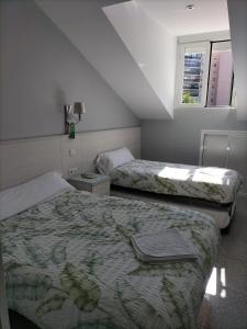 科斯拉达Hostal San Pedro的酒店客房设有两张床和窗户。