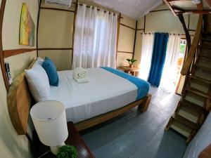 蓬塔露奇亚Rustic House Punta Rucia的一间卧室配有一张带蓝色枕头的床,并设有一个楼梯