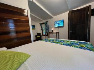 库尔克岛Colinda Cabanas的卧室配有白色的床和木门