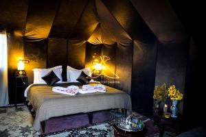 伊尔富德Sahara Desert Camping Merzouga & Erg Chebbi Dunes的一间卧室配有一张床,上面有两条毛巾