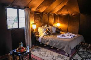 伊尔富德Sahara Desert Camping Merzouga & Erg Chebbi Dunes的一间卧室设有一张床和一个窗口