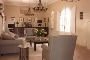 塔鲁丹特Palais Villa Talaa Resort的客厅配有椅子和鲜花桌