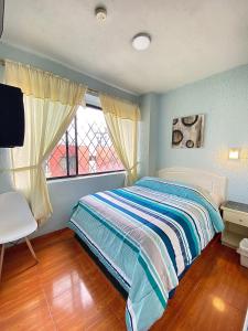 基多Hostal Brilliant的一间卧室设有一张床和一个窗口