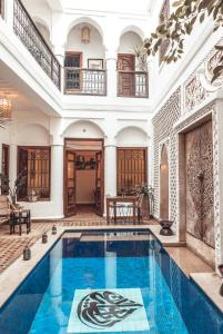 马拉喀什Riad Dar Beldia and Spa的一座室内游泳池,位于一座拥有大房子的建筑中