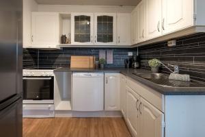 特罗姆瑟Spacious modern apartment, close to nature的厨房配有白色橱柜和水槽