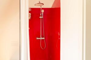 比勒费尔德Luxuriöses Penthouse mit Dachterrasse & Massagesessel EM-APARTMENTS DEUTSCHLAND的红色淋浴的浴室,带有红色的墙壁