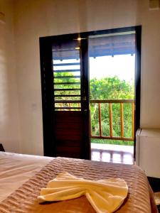 卡拉伊瓦Mirante Caraiva的一间卧室配有一张床,一扇门设有窗户