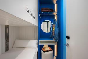 马拉加COEO Pod Hostel - Part of COEO Experience的一间小卧室,配有一张床和蓝色的墙壁