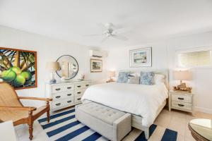 基克罗尼海滩Casa Del Mar的白色卧室配有床和椅子