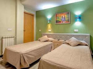 阿兰约兹里尔阿兰胡埃斯旅馆的绿墙客房内的两张床