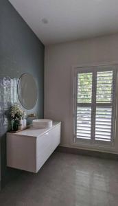 奥尔伯里Location & luxury 2BR 2 Bath的一间带水槽和镜子的浴室以及窗户。