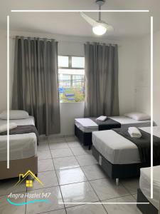安格拉杜斯雷斯Angra Hostel 147的一间卧室设有两张床和窗户。