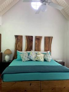 克朗角Reefside Villa的一间卧室配有一张带蓝色床单和枕头的床。