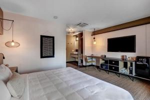 棕榈泉Mahala的配有一张床和一台平面电视的酒店客房